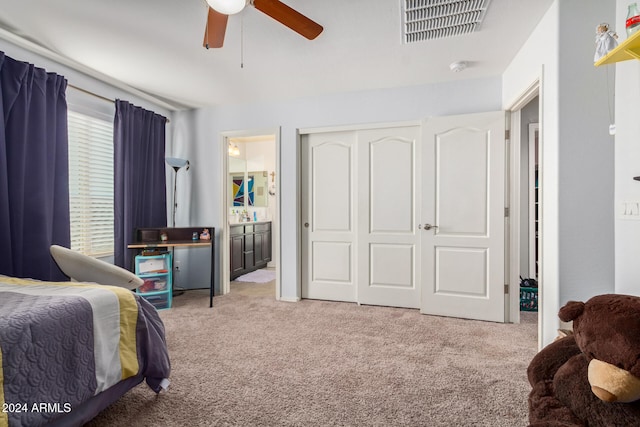 bedroom with a closet, light colored carpet, ceiling fan, and ensuite bathroom