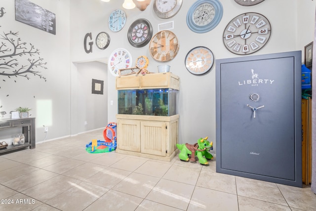 playroom with tile patterned flooring and a high ceiling