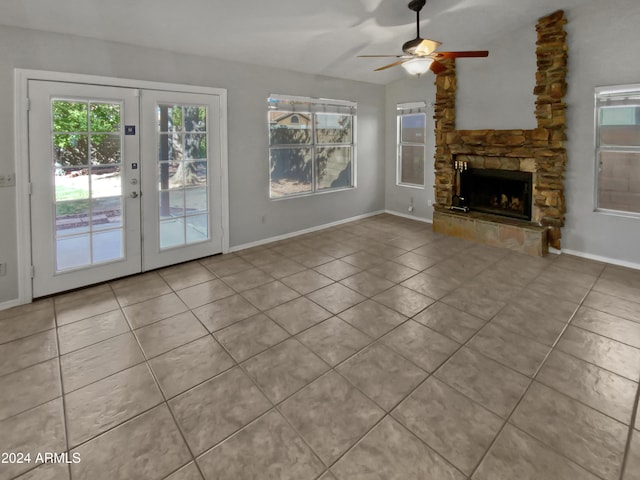 unfurnished living room with french doors, a fireplace, light tile patterned floors, and ceiling fan