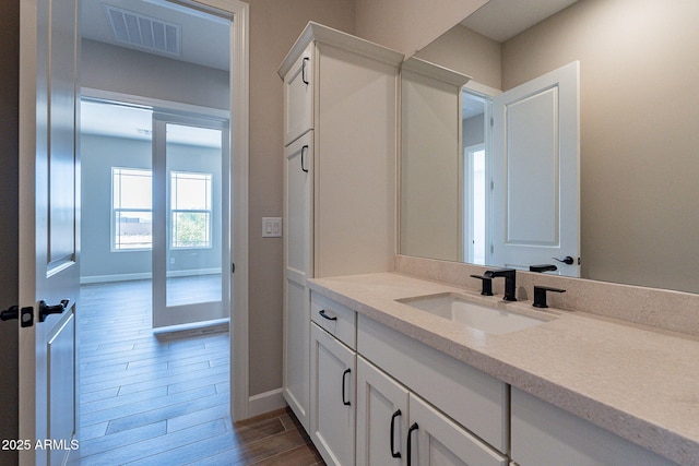 bathroom featuring baseboards, vanity, visible vents, and wood tiled floor