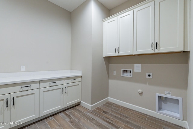 laundry room with hookup for a gas dryer, hookup for an electric dryer, baseboards, cabinet space, and wood tiled floor