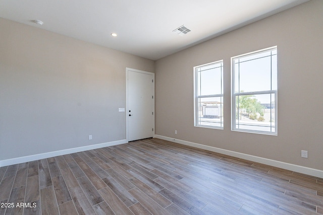 spare room featuring recessed lighting, visible vents, baseboards, and wood finished floors