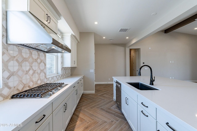 kitchen featuring visible vents, decorative backsplash, appliances with stainless steel finishes, a sink, and under cabinet range hood