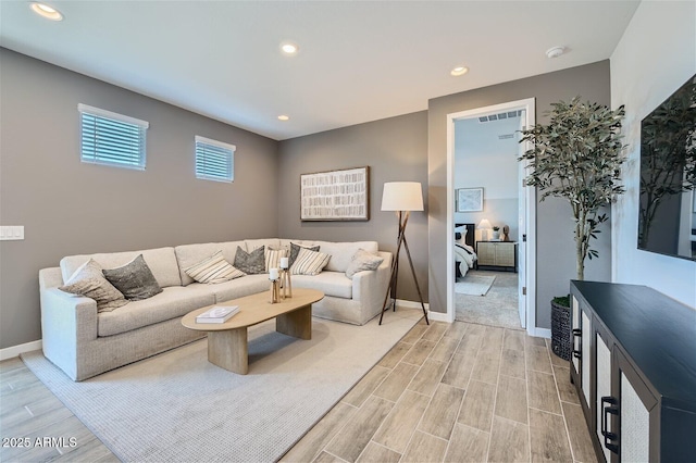 living area featuring light wood-style floors, baseboards, and recessed lighting