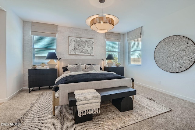 carpeted bedroom featuring baseboards and multiple windows