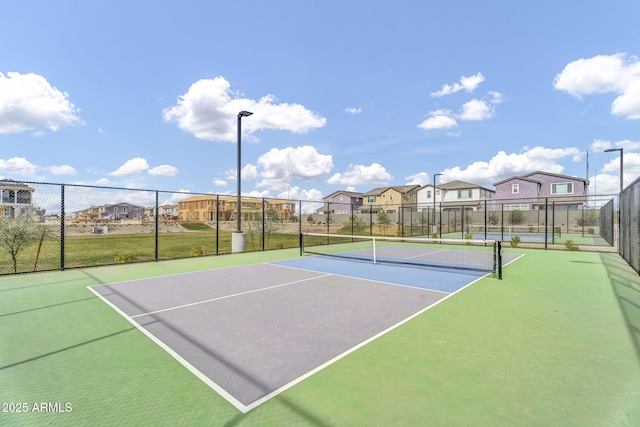 view of sport court featuring fence, community basketball court, and a residential view