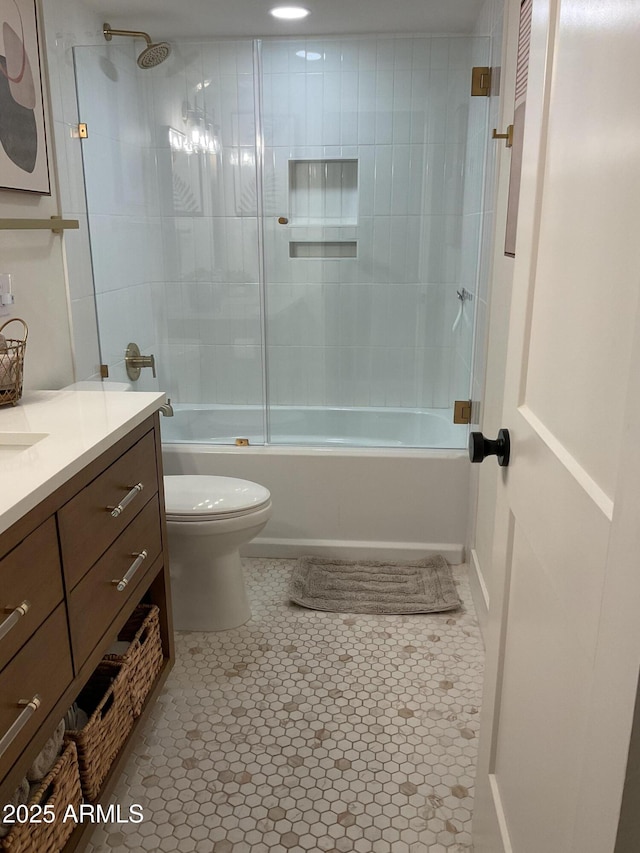 full bathroom with tile patterned flooring, vanity, tiled shower / bath combo, and toilet