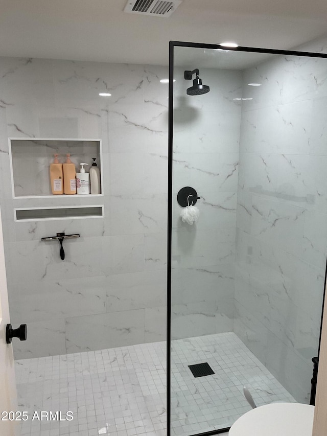 bathroom with toilet and tiled shower