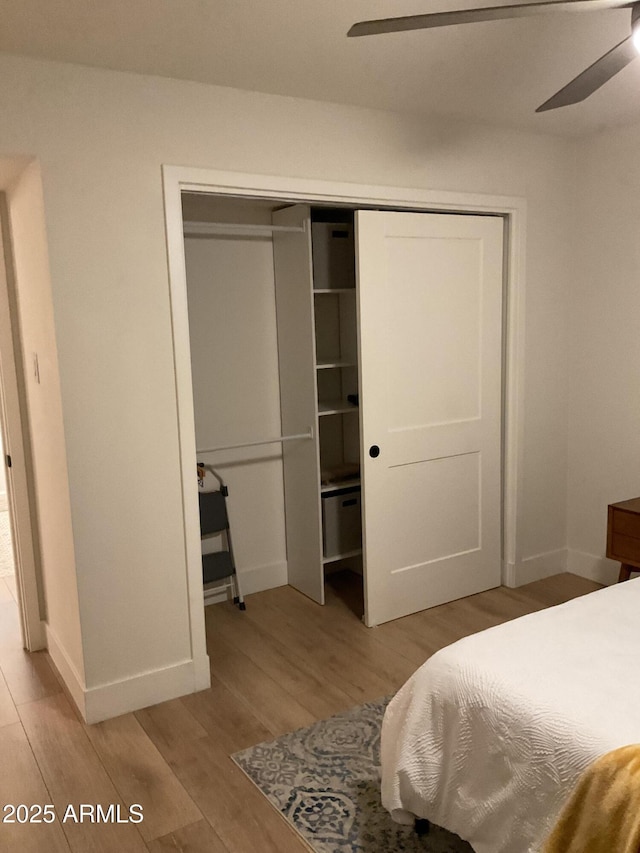 bedroom with ceiling fan, light hardwood / wood-style floors, and a closet