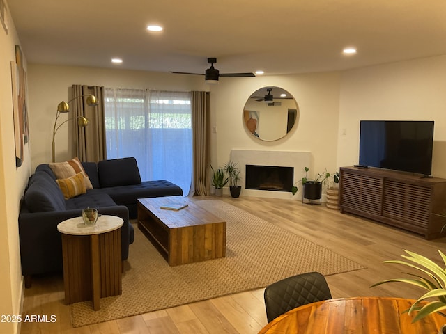 living room with ceiling fan and light hardwood / wood-style flooring