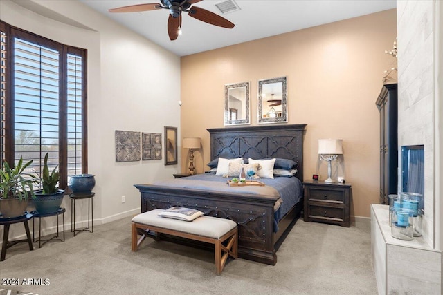 carpeted bedroom featuring multiple windows and ceiling fan