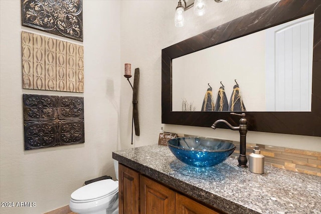 bathroom with vanity, backsplash, and toilet