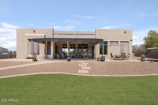 back of house featuring ceiling fan, a yard, and a patio