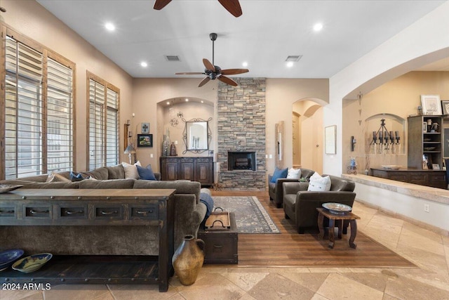 living room featuring a fireplace, ceiling fan, and light hardwood / wood-style flooring