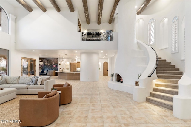 interior space with beamed ceiling, plenty of natural light, and a towering ceiling