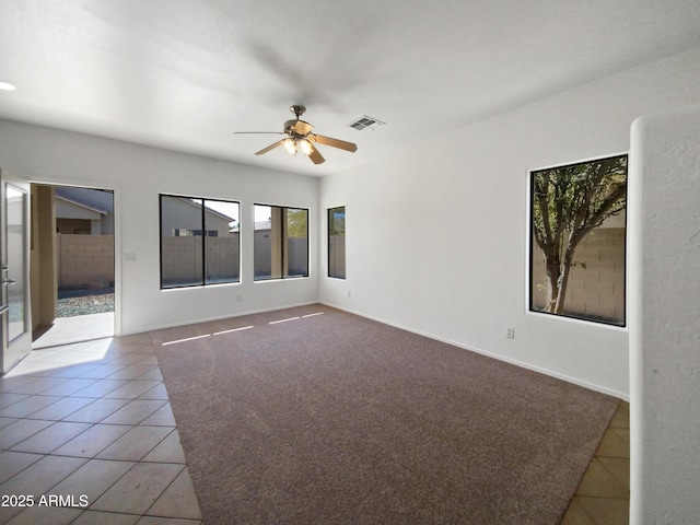 empty room with ceiling fan and light tile patterned floors