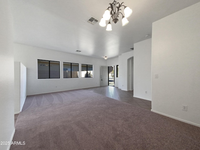 tiled empty room featuring a chandelier