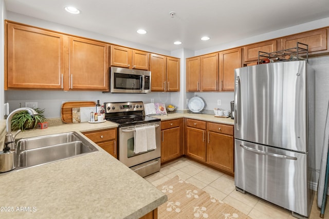 kitchen with appliances with stainless steel finishes, light tile patterned floors, and sink