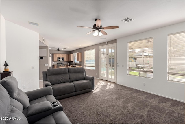 carpeted living room featuring ceiling fan and french doors