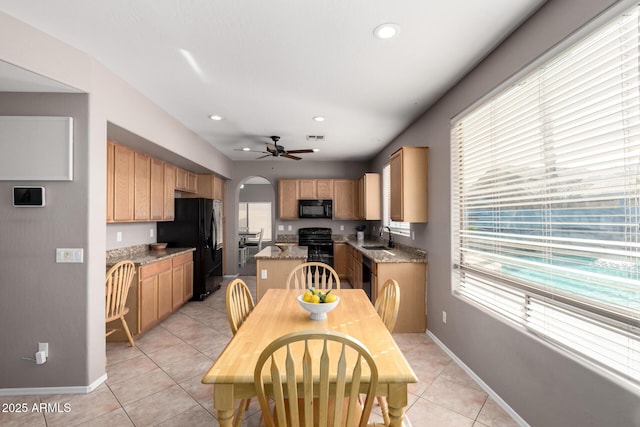 dining space featuring ceiling fan, sink, and light tile patterned floors