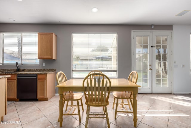 dining area featuring french doors, plenty of natural light, sink, and light tile patterned floors