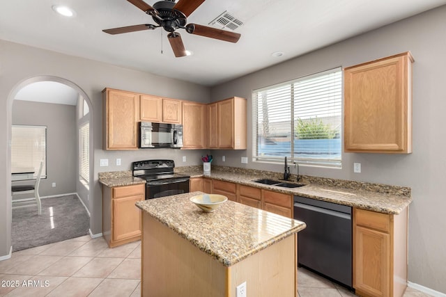 kitchen with sink, light stone counters, a center island, light brown cabinets, and black appliances