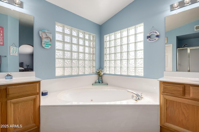 bathroom with vanity, vaulted ceiling, and shower with separate bathtub