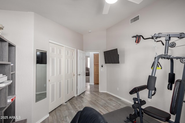 workout area with ceiling fan and light hardwood / wood-style floors