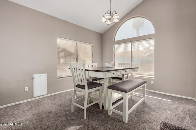 carpeted dining space featuring high vaulted ceiling and a chandelier