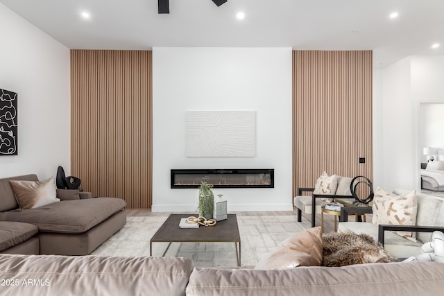 living room with recessed lighting, a glass covered fireplace, and ceiling fan