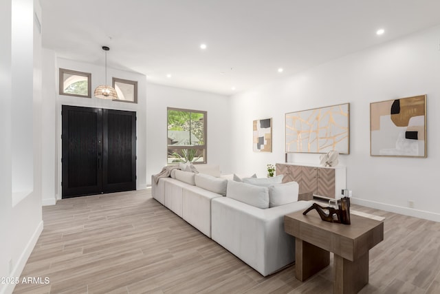 living room featuring light wood-style floors, recessed lighting, and baseboards