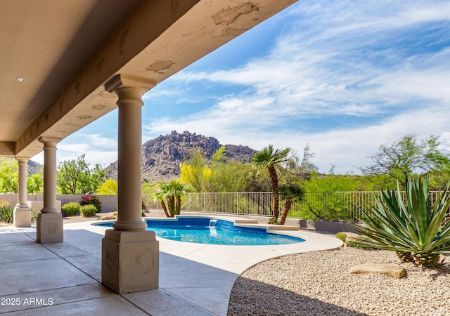 view of pool with a fenced backyard, a mountain view, and a patio