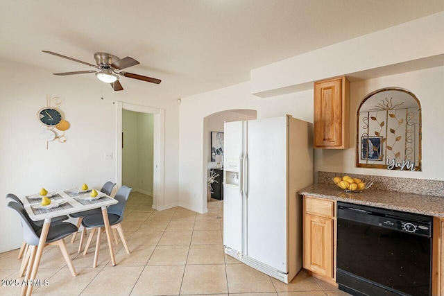 kitchen with light tile patterned floors, black dishwasher, arched walkways, and white fridge with ice dispenser