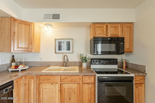 kitchen with a sink, visible vents, and black appliances