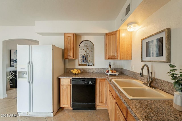 kitchen with light tile patterned floors, visible vents, a sink, black dishwasher, and white refrigerator with ice dispenser