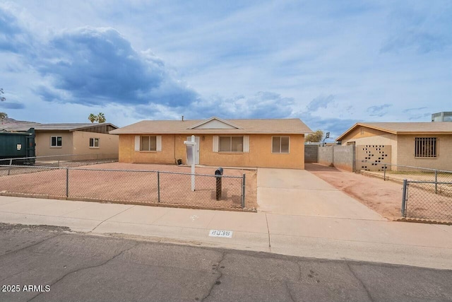 view of front of house with a fenced front yard, driveway, and stucco siding