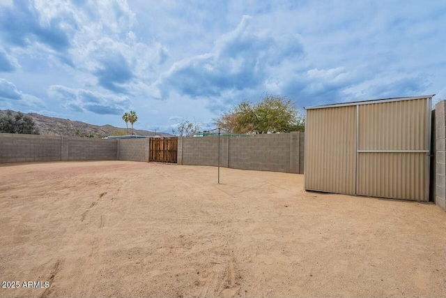 view of yard with an outbuilding, a mountain view, and a fenced backyard