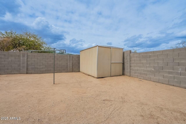 view of yard featuring a storage unit, an outdoor structure, and a fenced backyard