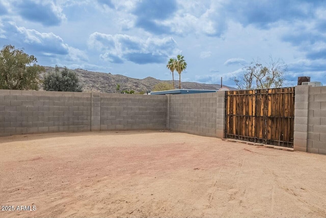 view of yard with a gate, a mountain view, and fence