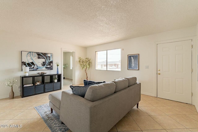 living area with light tile patterned flooring, baseboards, and a textured ceiling