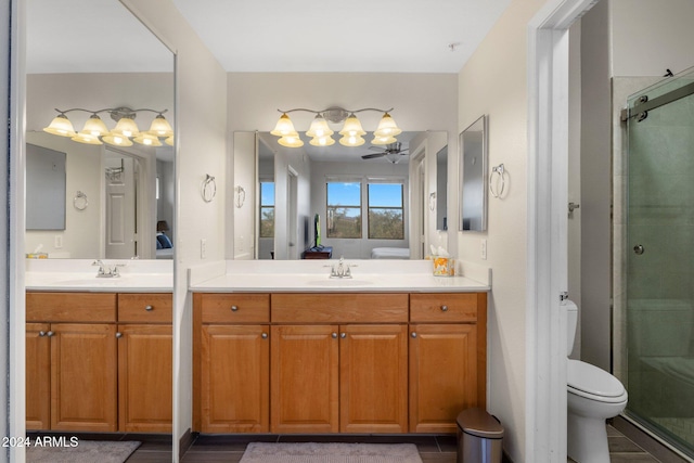 bathroom with ceiling fan, vanity, a shower with shower door, and toilet