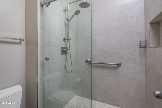 bathroom with toilet and a tile shower