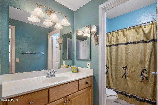 bathroom featuring a chandelier, vanity, toilet, and curtained shower