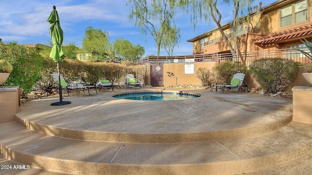 view of swimming pool with a patio area and a hot tub