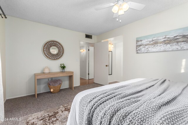 bedroom with ceiling fan, carpet, and a textured ceiling