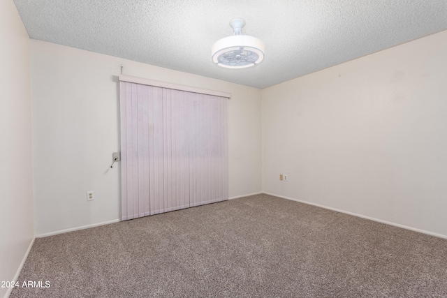 unfurnished room with carpet floors and a textured ceiling