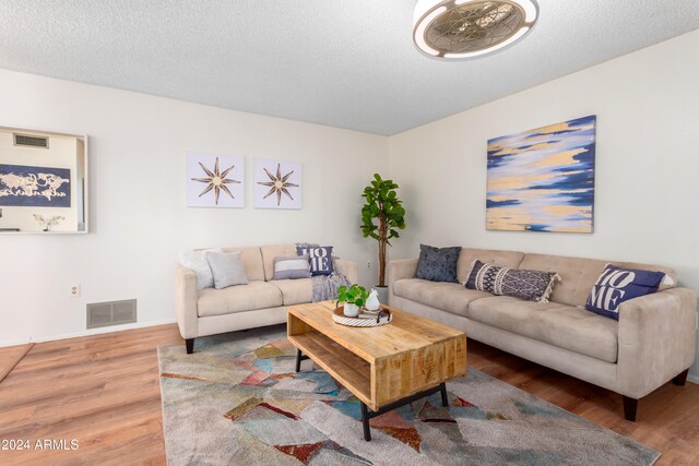 living room with hardwood / wood-style floors and a textured ceiling