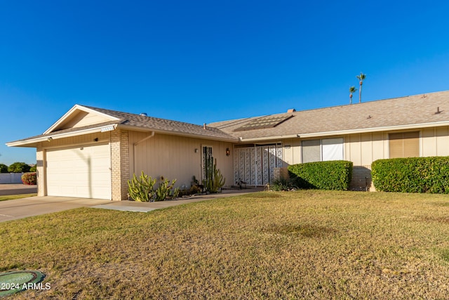 ranch-style home with a garage and a front lawn