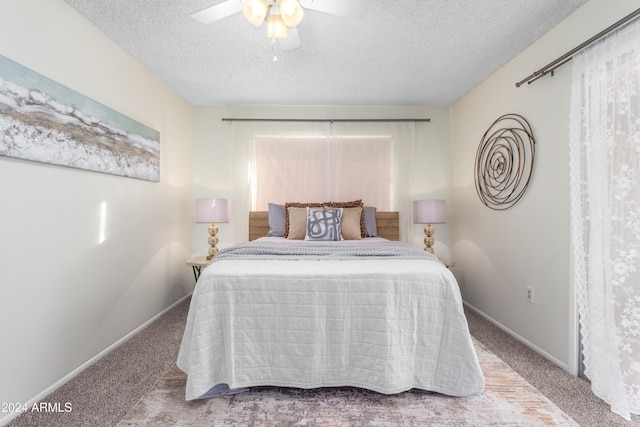 bedroom with ceiling fan, carpet, and a textured ceiling