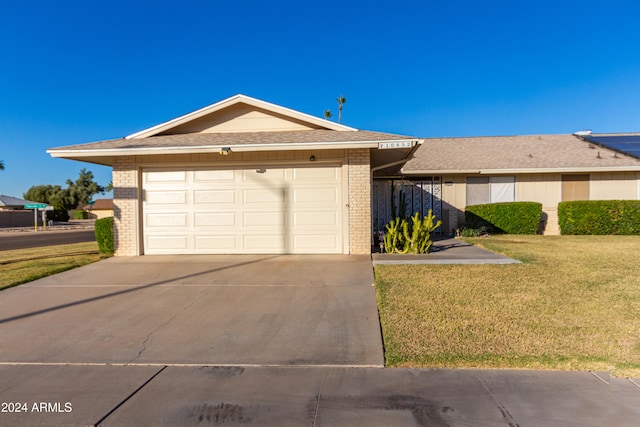 single story home with a garage and a front lawn